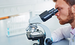 Учёный смотрит в микроскоп